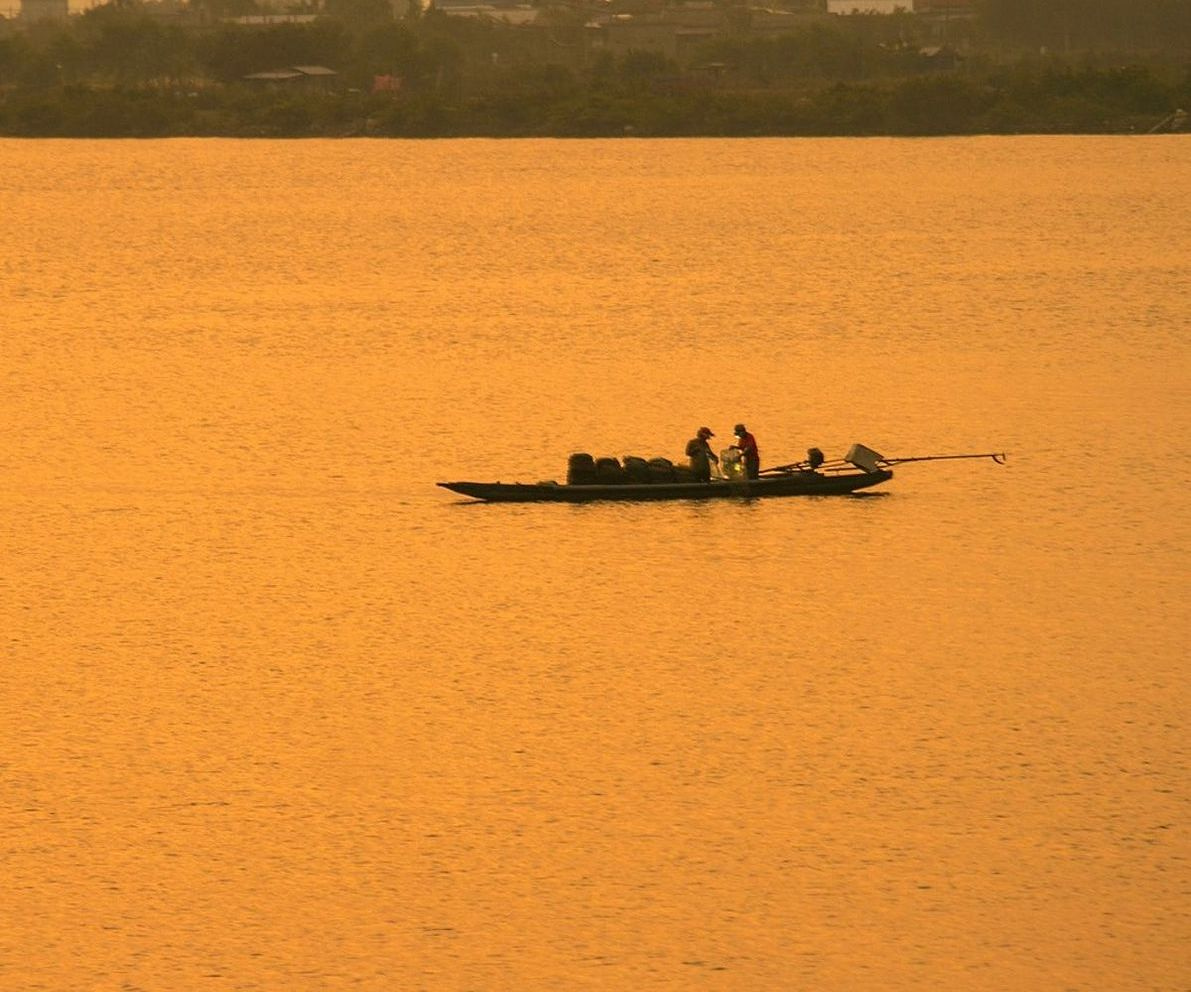 Pescador com sua captura do dia no lago da montanha